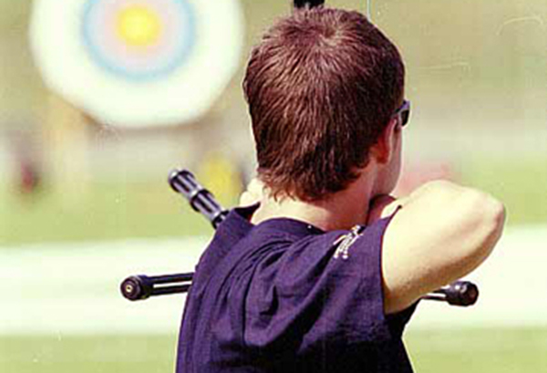 An archer aiming at the target in the background
