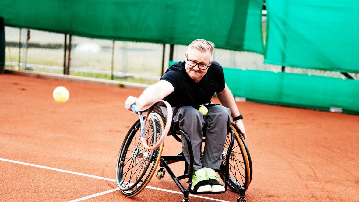 Man in wheelchair playing tennis