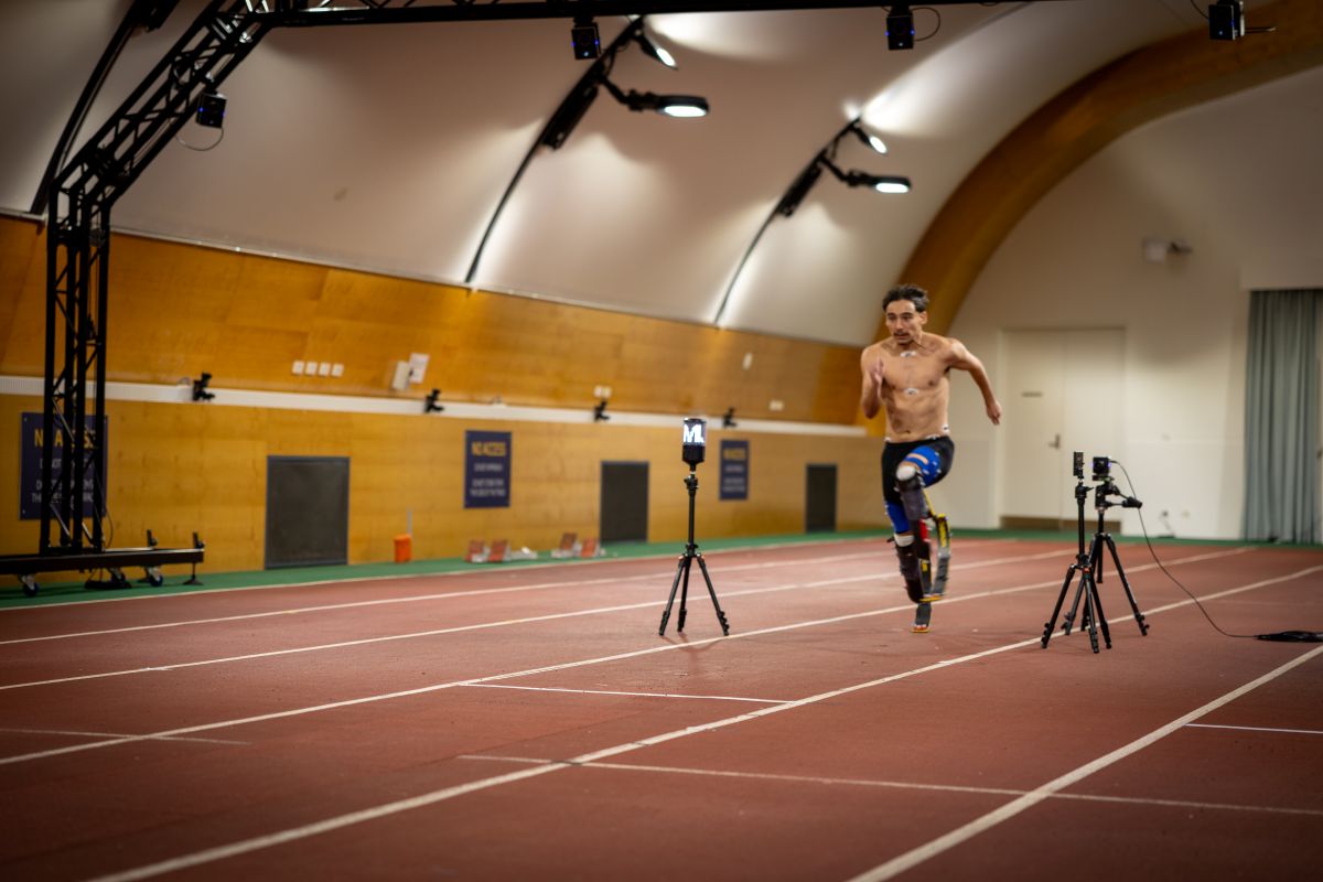 Young Para athlete Alex Mijailovic on running blades mid-sprint at the AIS indoor track