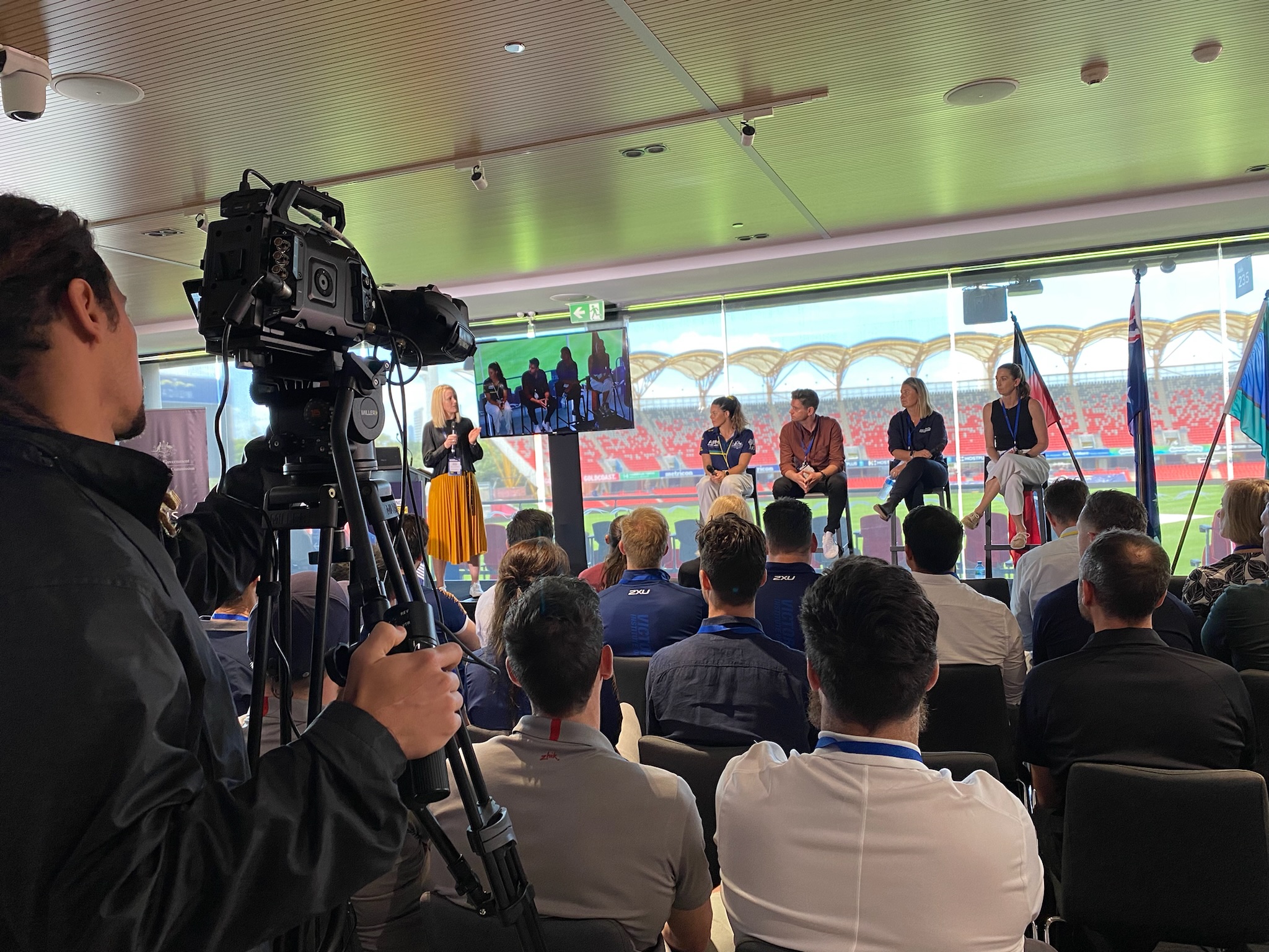 Image of people sitting on a stage on stools