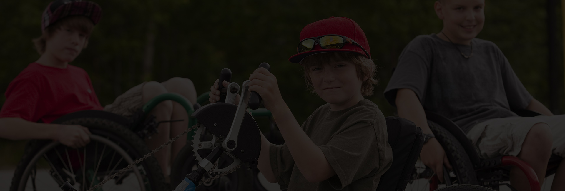 Young boys sitting in wheelchairs and a hand cycles