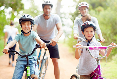 A mother, father and two young children riding their bikes