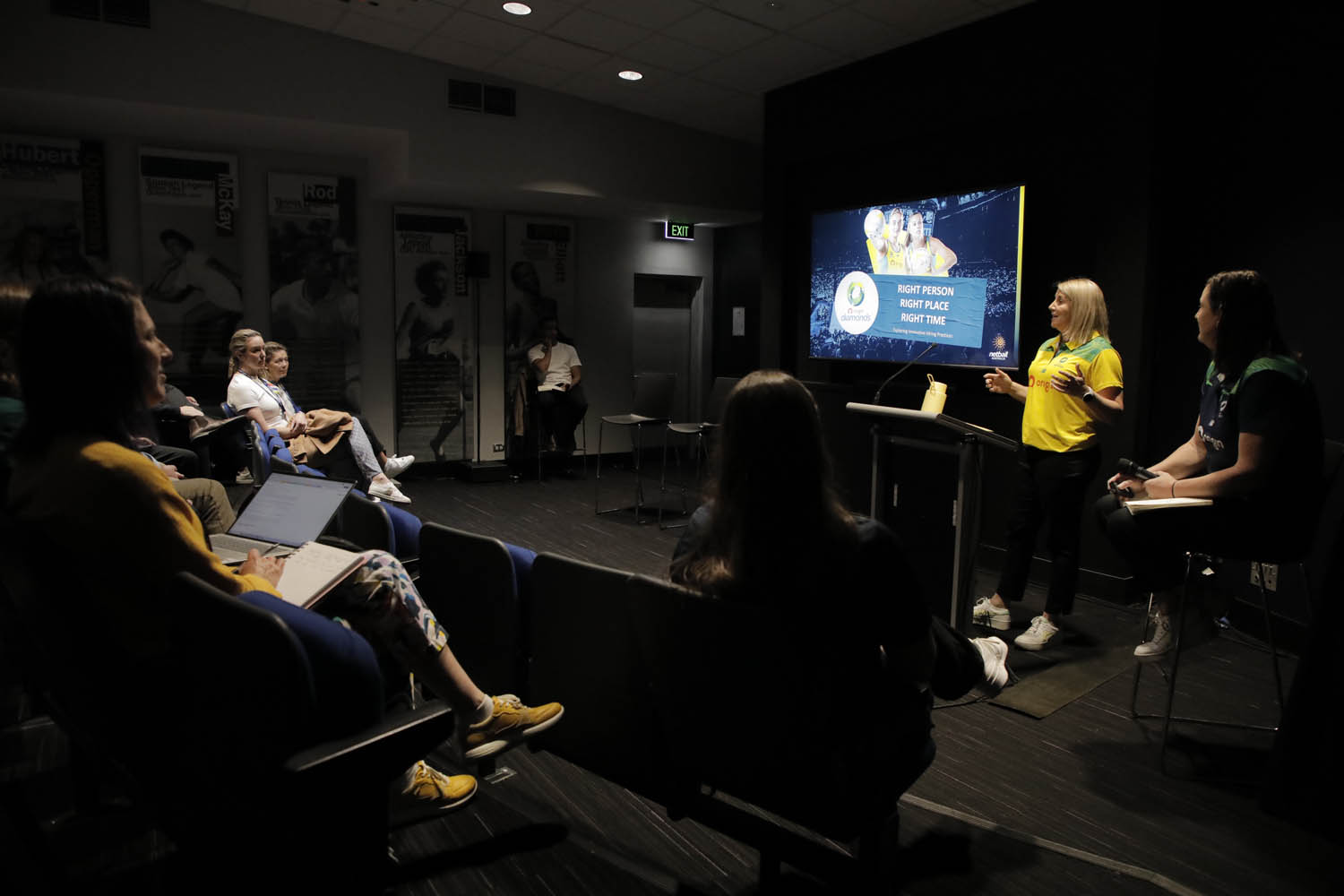 Two people at the front of a dark theatrette