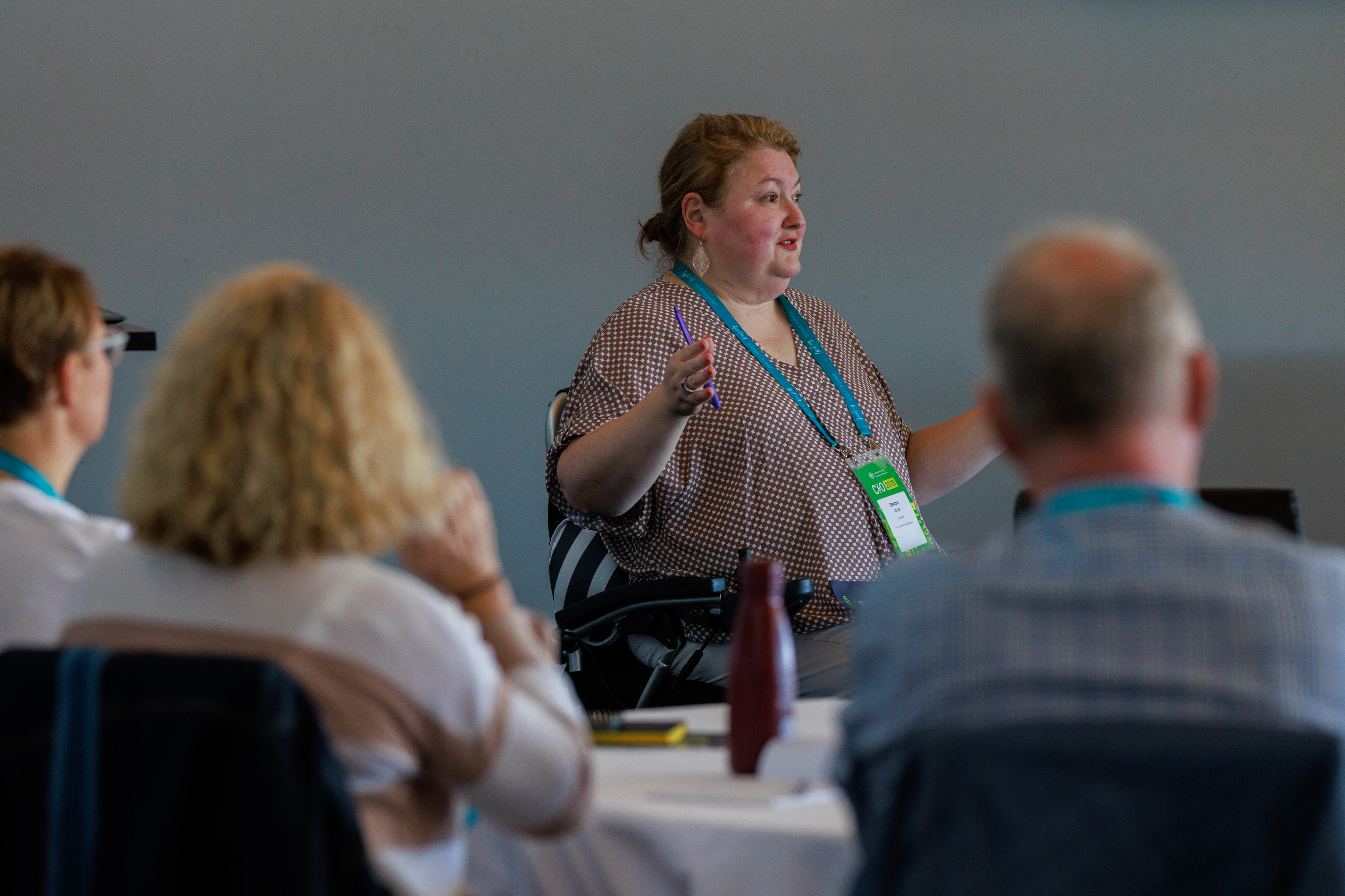 Facilitator in wheelchair talking to group