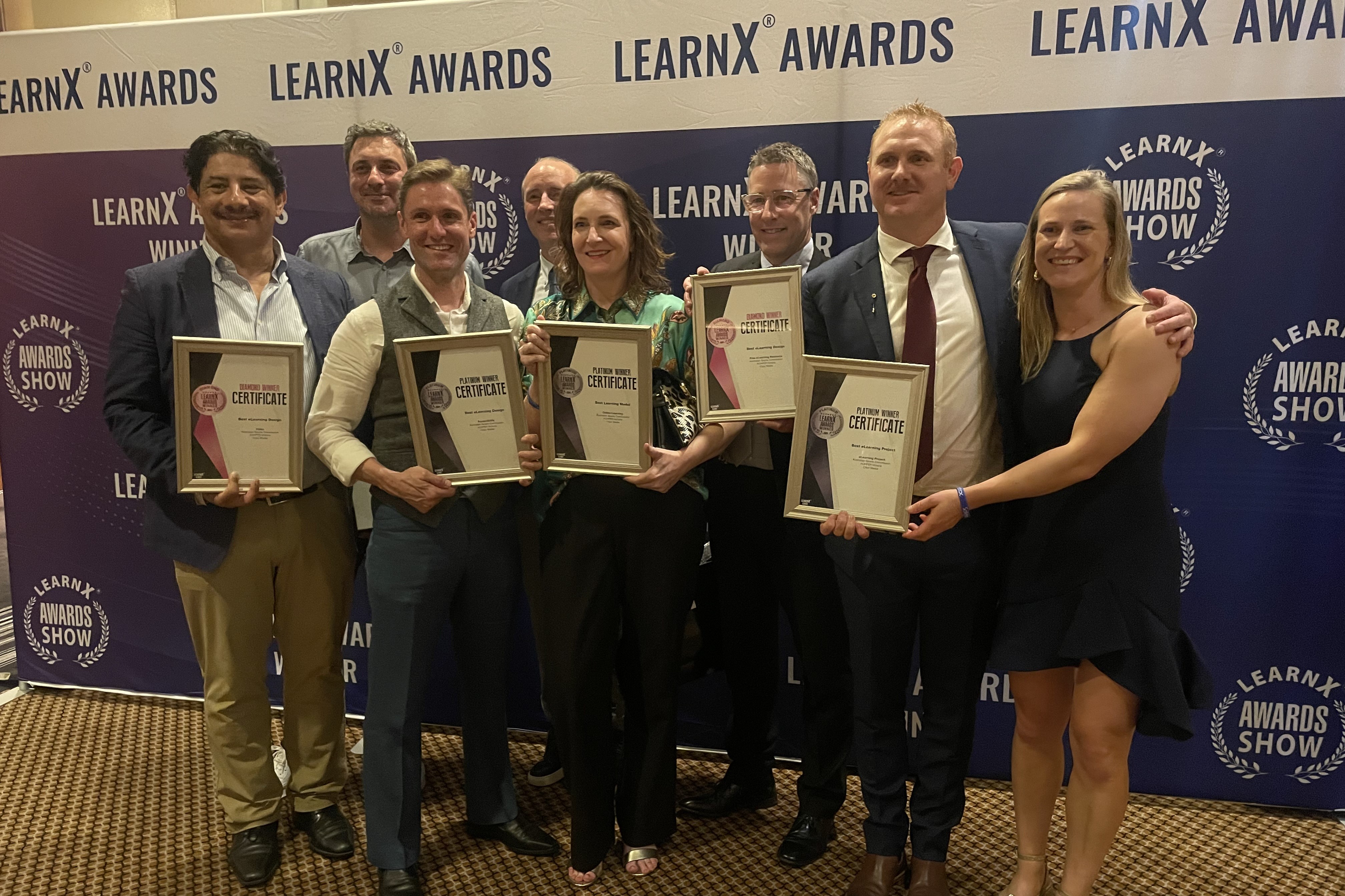 Eight members of the team behind the 'PE – Essential skills for primary teachers' course holding their five LearnX Awards.