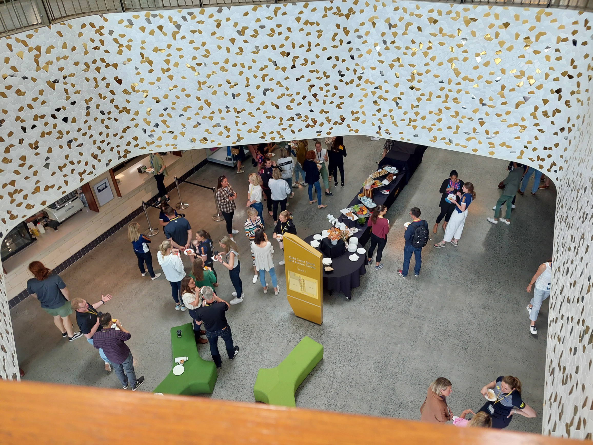 A crowd of people talking eating morning tea