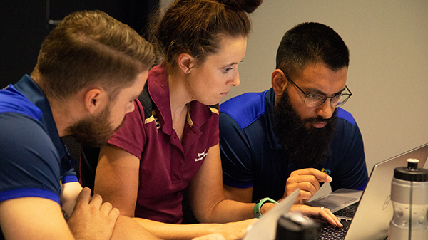 Workshop attendees from the National Institute Network ( NIN ) looking at information on a computer.