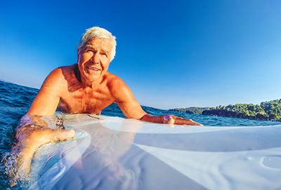 C4S-evidence-mature-aged-sport-Mature age man lying on a surfboard