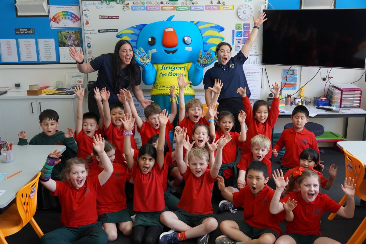 Athletes Caitlin Parker and Georgia Godwin in a classroom with primary school kids
