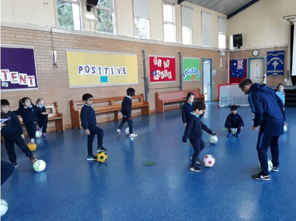 Sporting Schools - Students playing football indoors