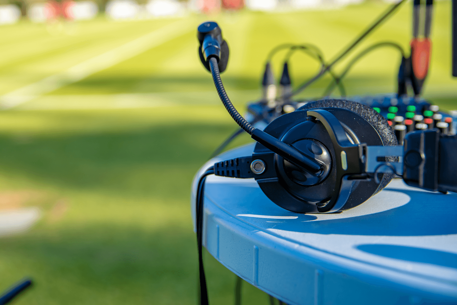 Microphone headset and mixing board next to a sporting field