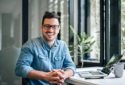 Man sitting at a desk smiling at the camera