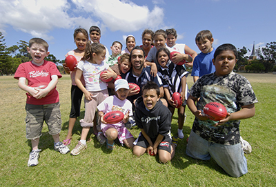 C4S-EB-Australian Sport History - Group of kids huddled around Adam Goodes