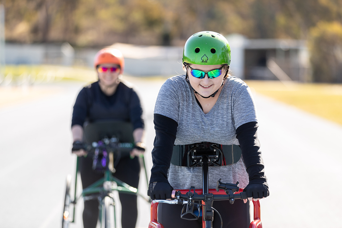 Two women on an athletics track participating in Para sport