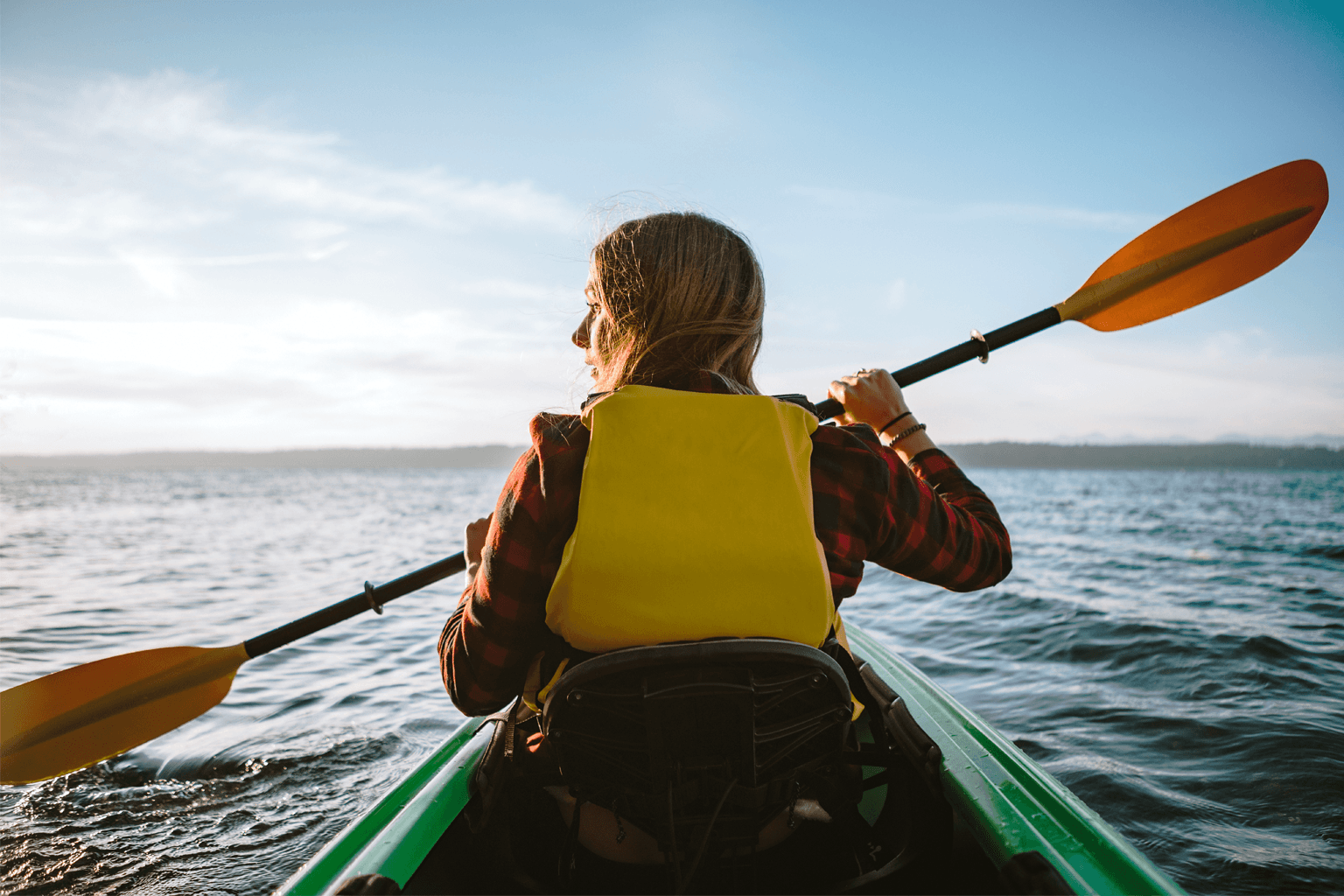 Young woman paddling in a sea kayak.