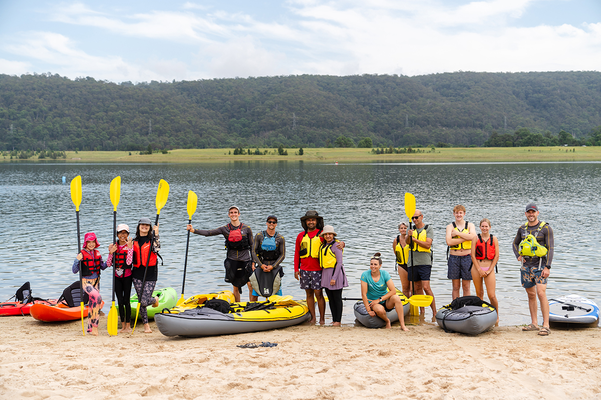 A group of paddlers standing by the water at Penrith Beach