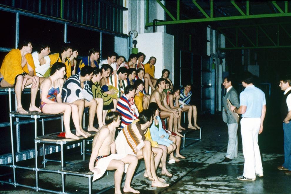 AIS Swimming team sitting on seats in the AIS pool
