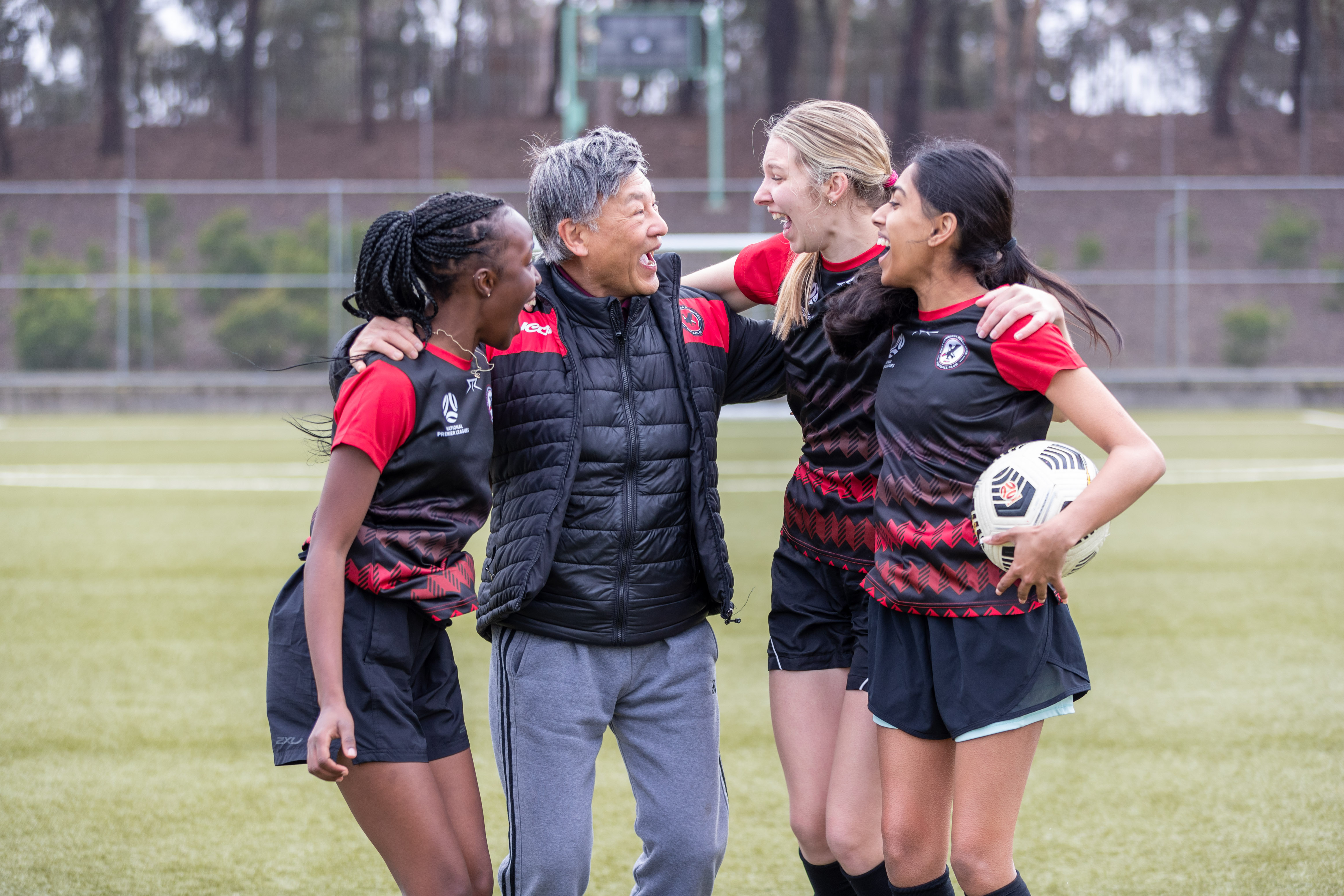 Coach and players celebrating on a soccer field