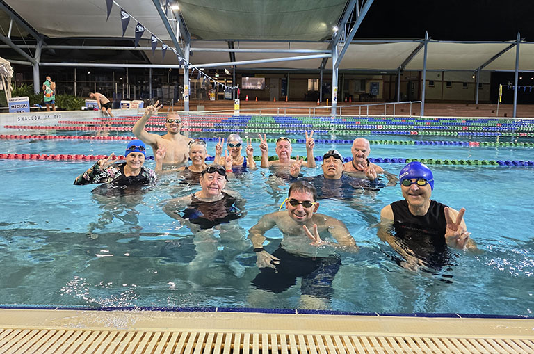 Image of adult swimmers celebrating in a pool.