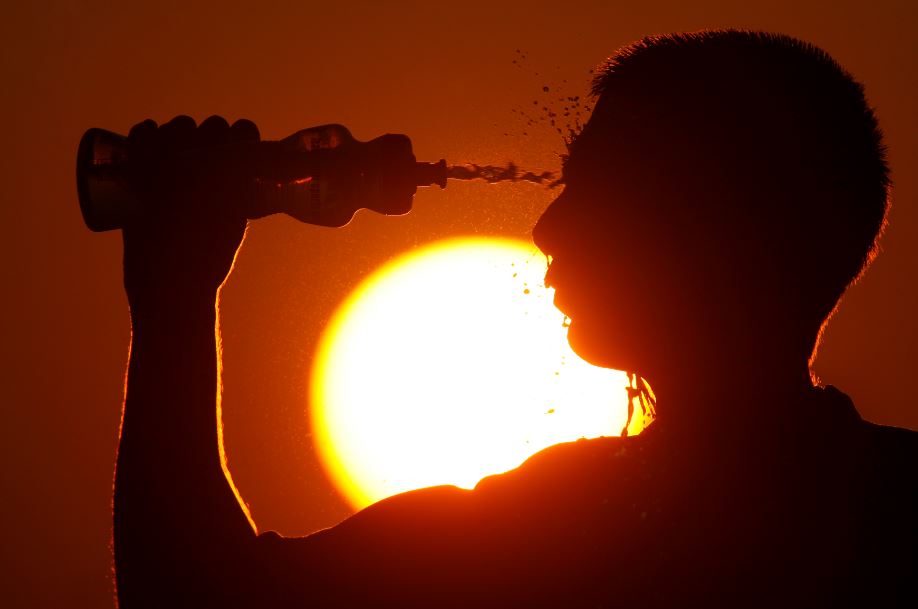 Athlete with drink bottle and sunset
