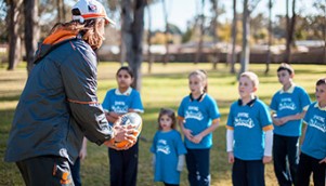 Coach teaching football to students