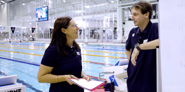 Mentor talking to mentee near swimming pool