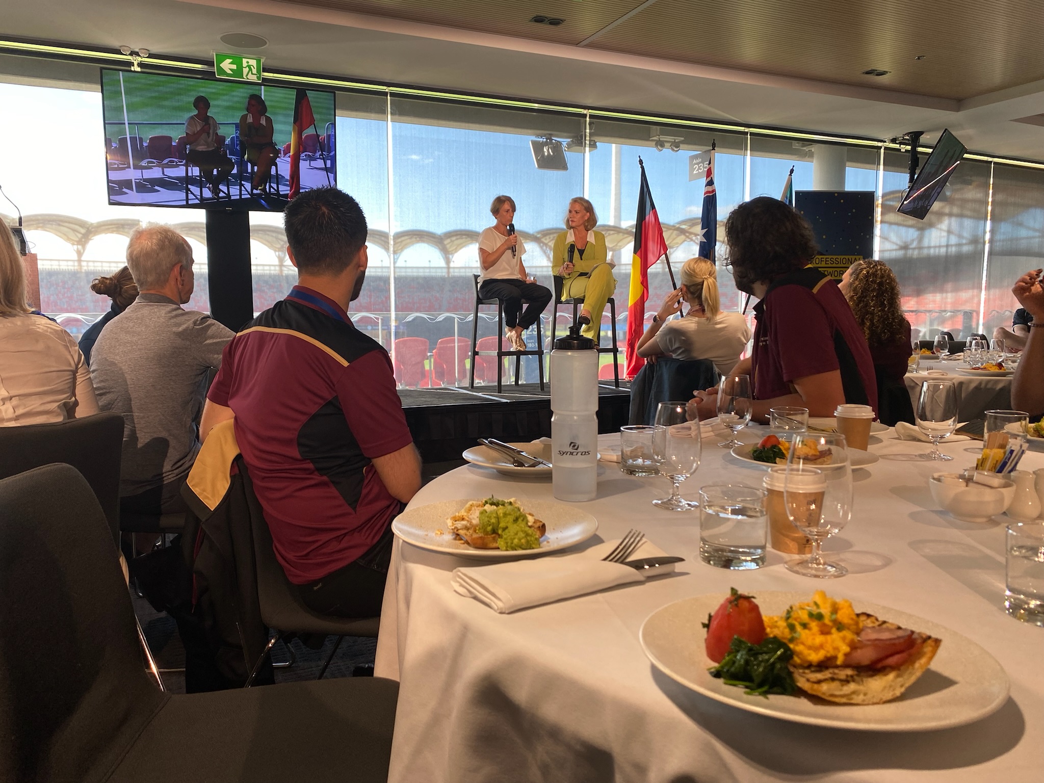 Two females speaking on stage to the crowd