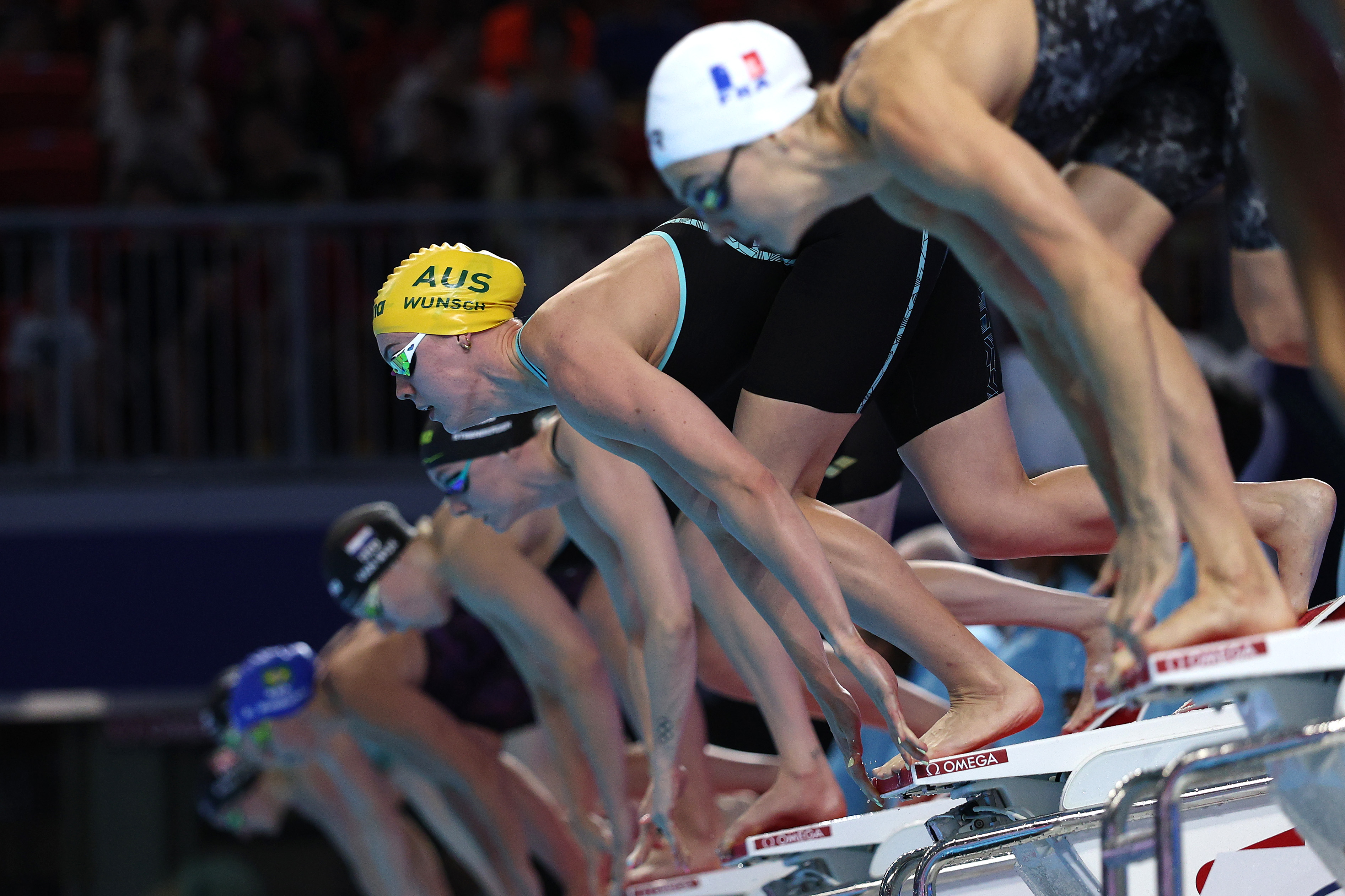 Female swimmer with yellow cap on start blocks before a race
