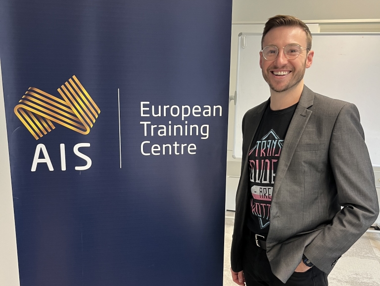 Matt standing next to AIS banner