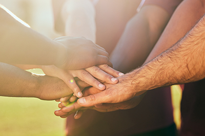 A group of hands placed together in the centre