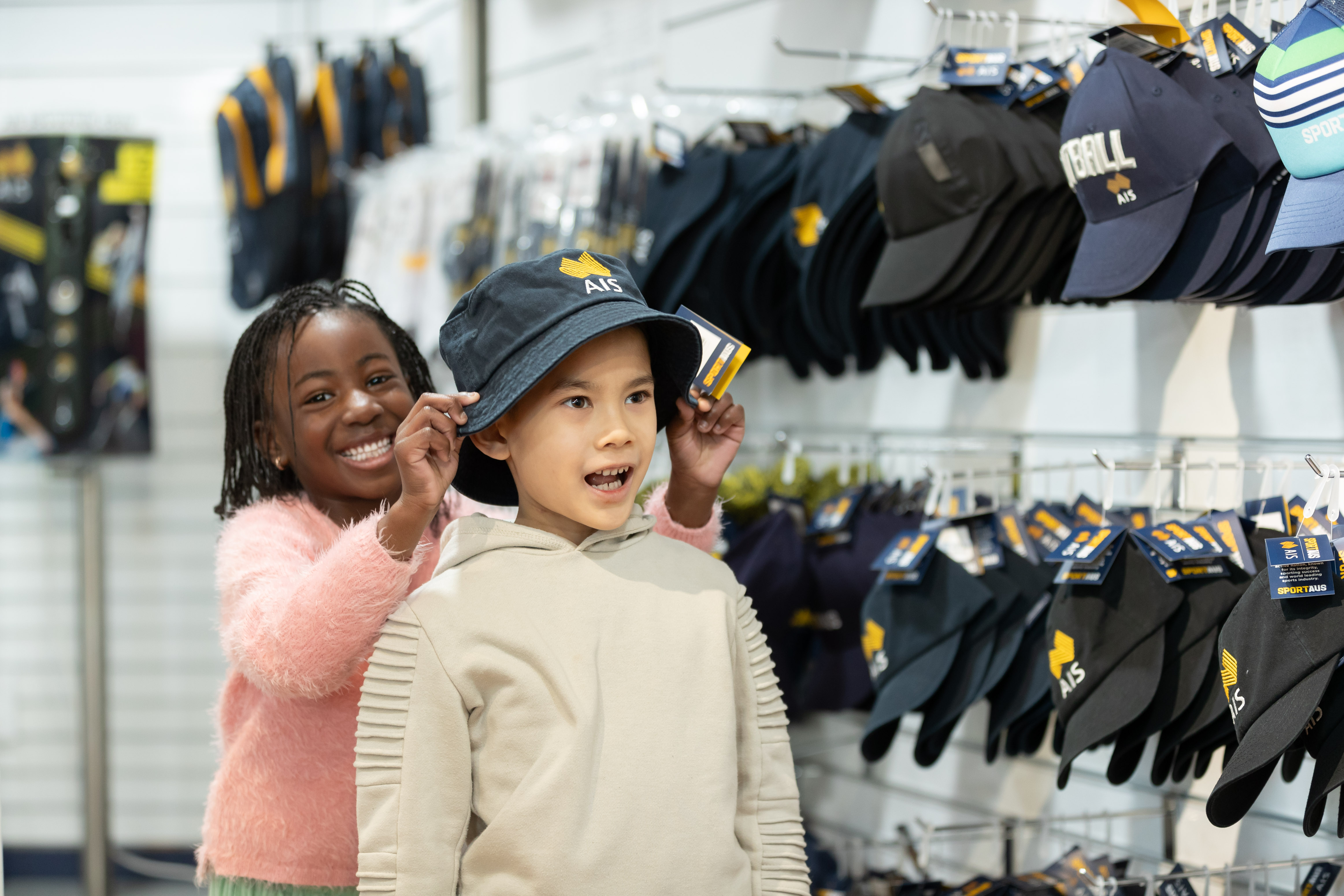 Children at the AIS shop trying on a hat
