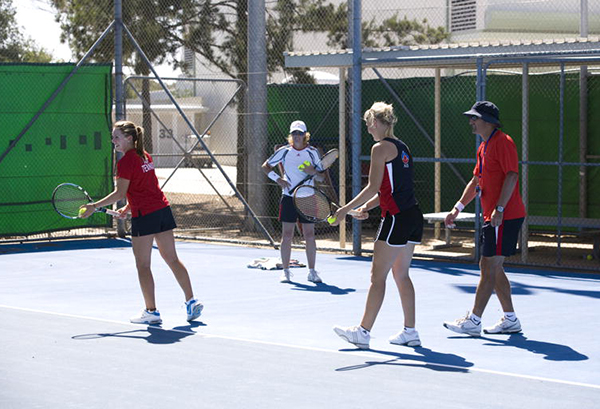 Tennis athletes and coaches at training