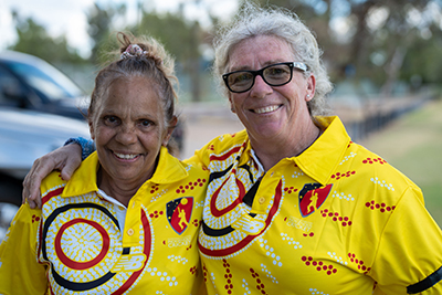 Two women with their arms around each other smiling at the camera
