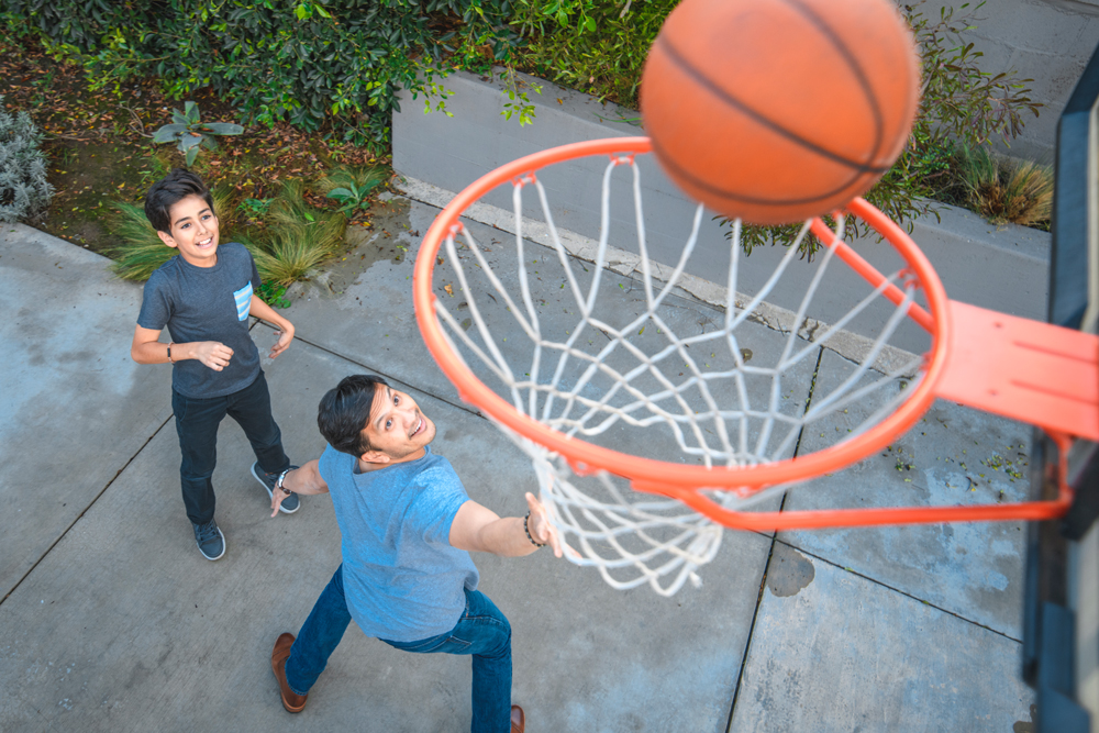 Dad and son playing basketball at home