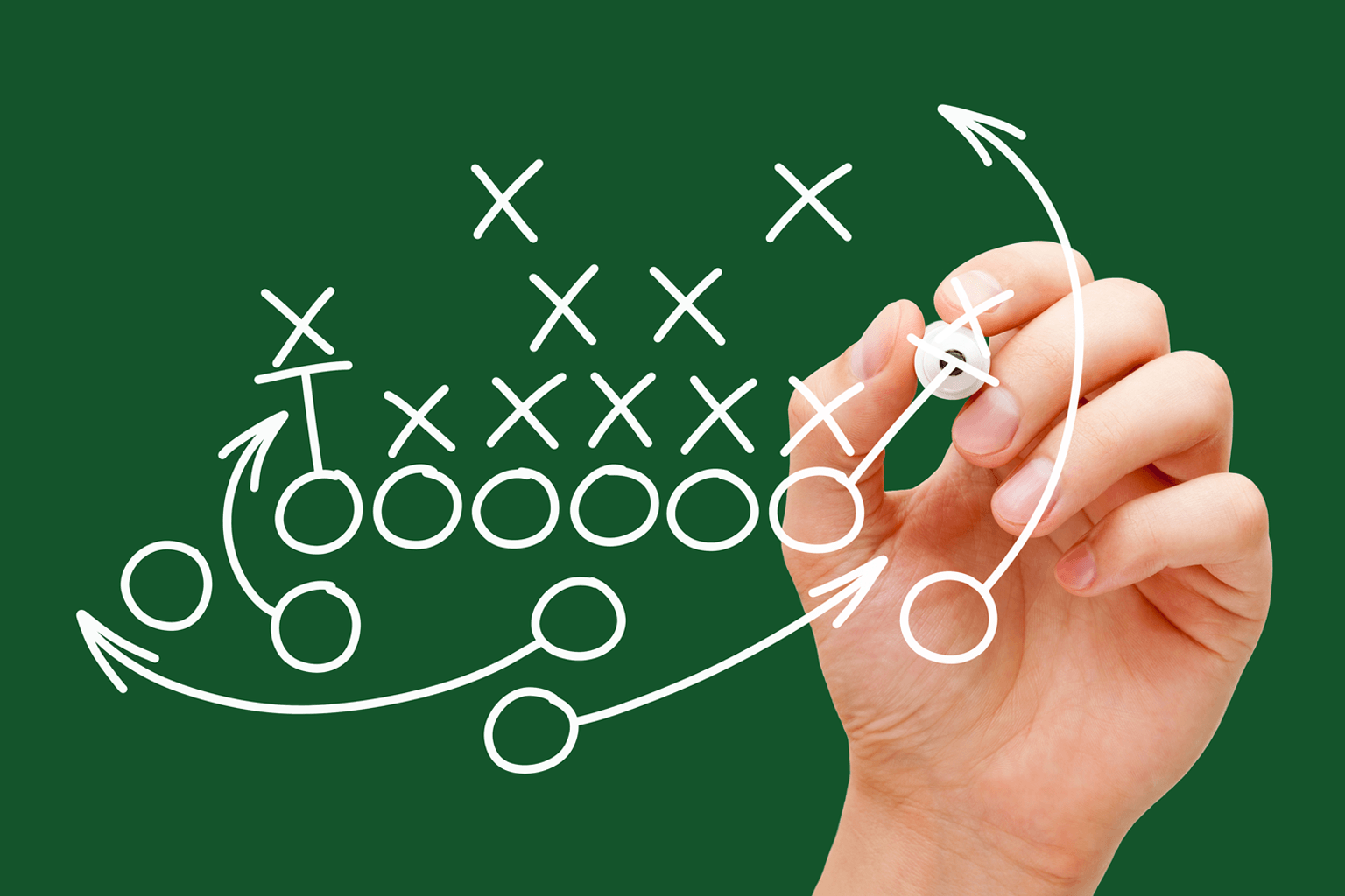 Hand drawing white marks on a board suggesting gameplan or strategy