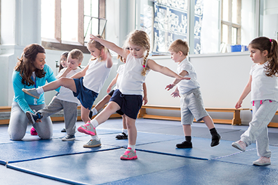 A teacher helping one of her students during a physical education lesson
