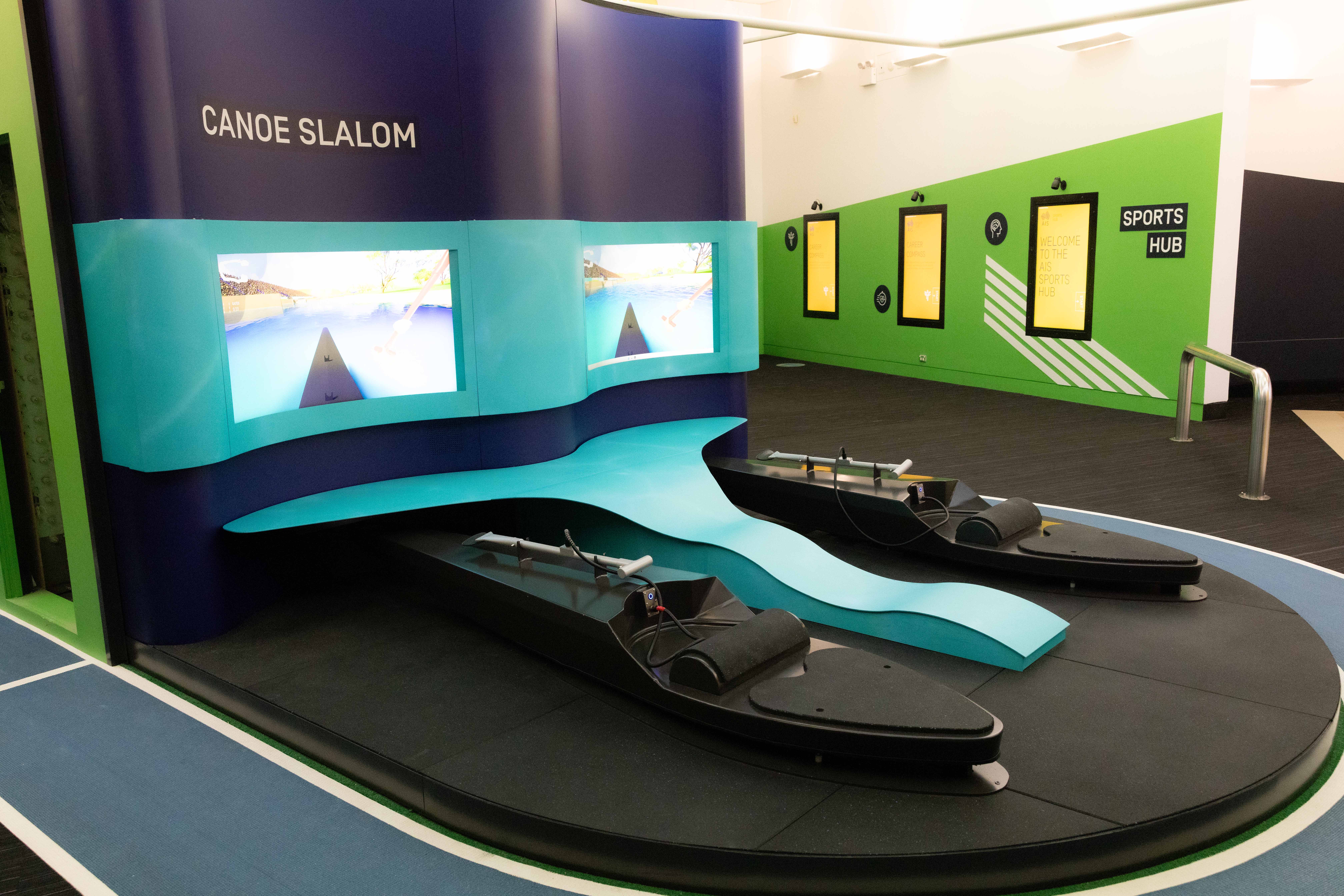 An image of the new canoeslalom interactive at Sportex, two canoes are on a raised platform linked to a video screen.