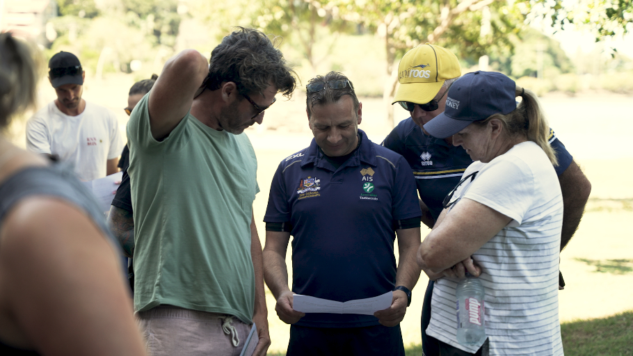 Group of coaches gathered around to discuss a challenge