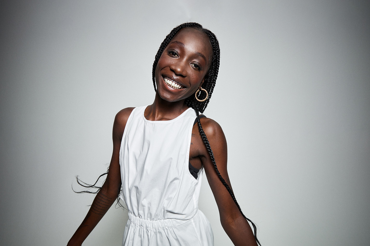 Athlete Bendere Oboya stands in front of a blank background, smiling