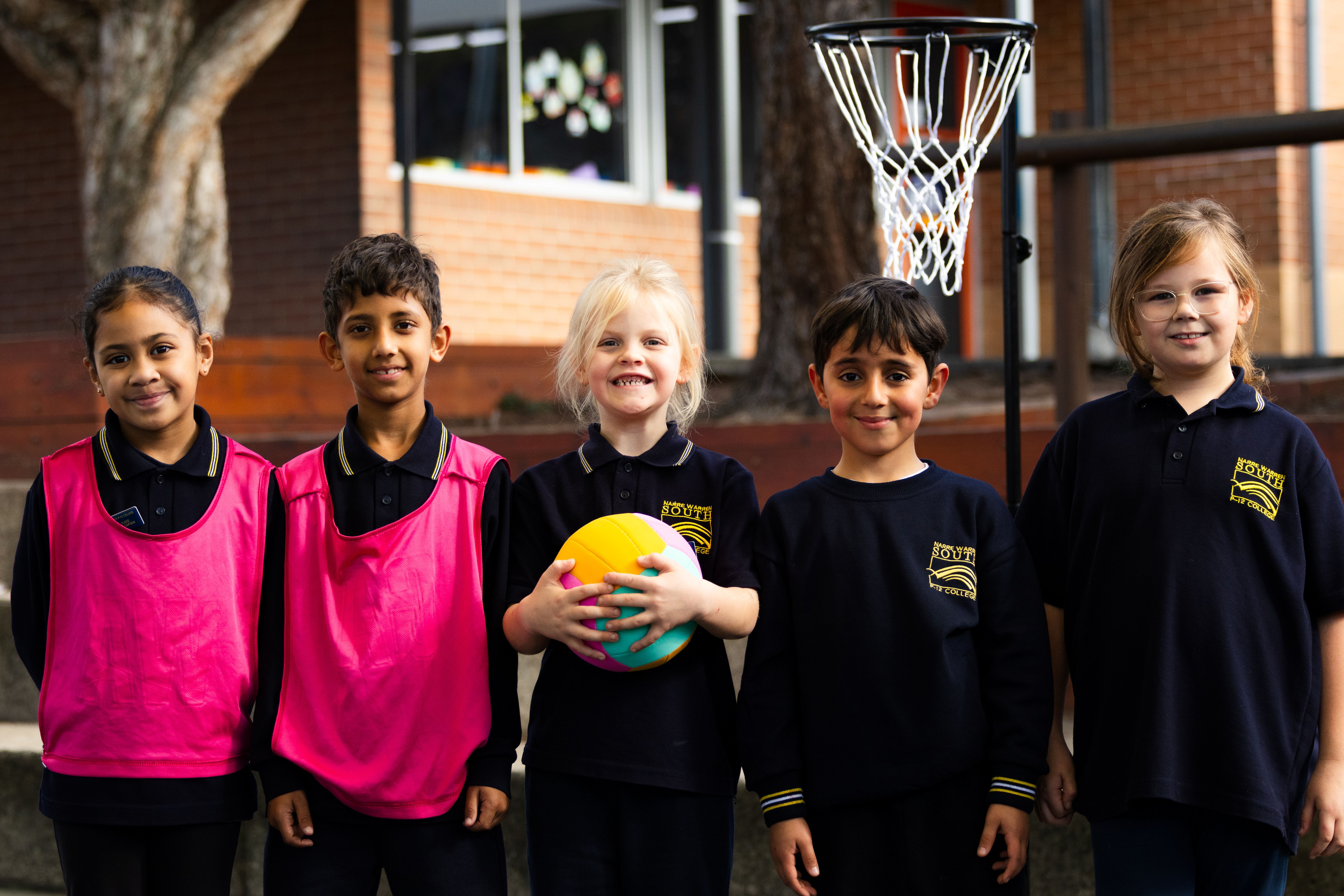 Group of children smiling and ready to play netball