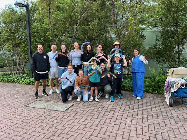 Group of 2024 Share a Yarn athletes holding boomerang