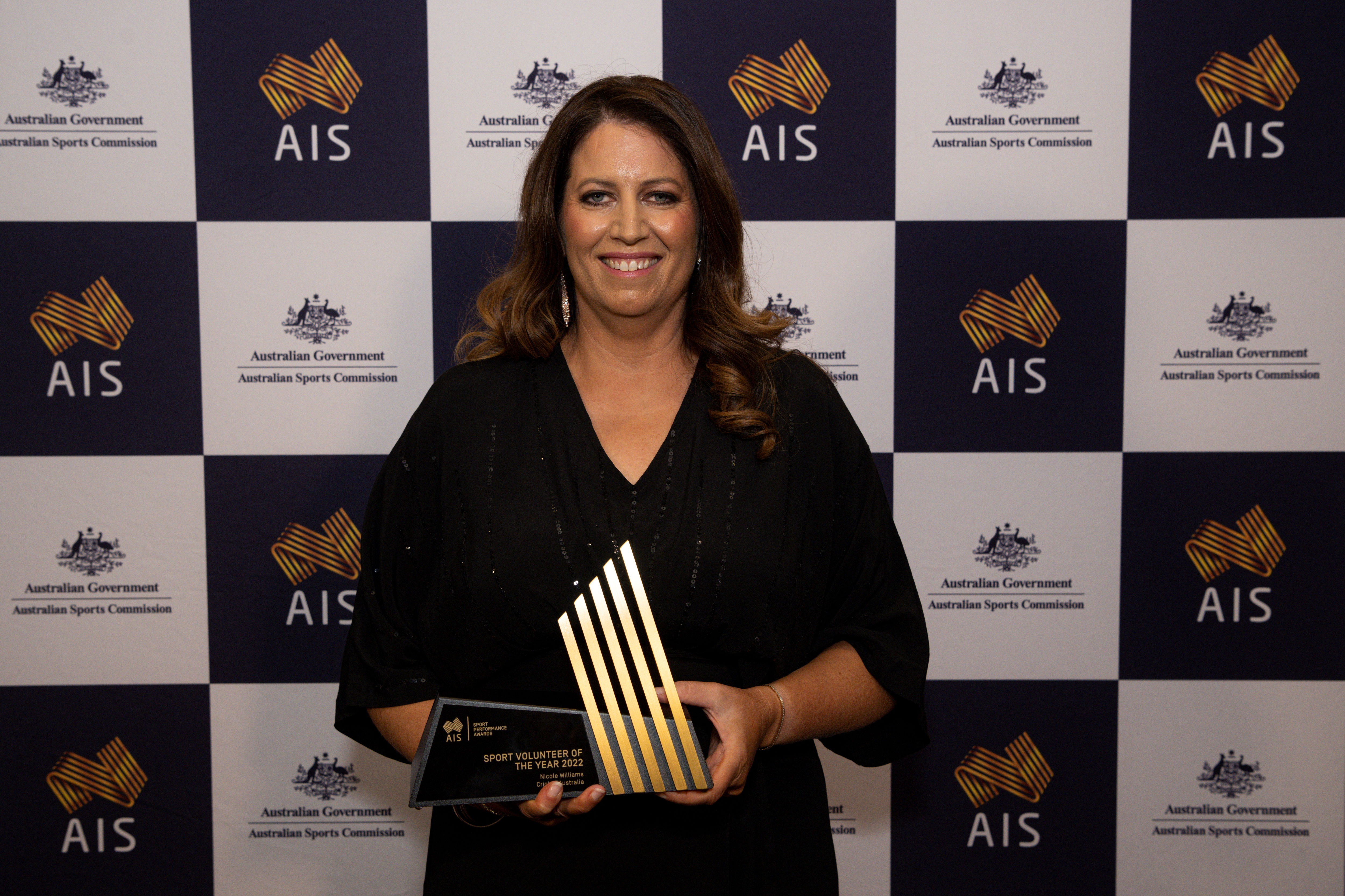 Nicole Williams holding 2022 Sport Volunteer of the Year Award trophy.
