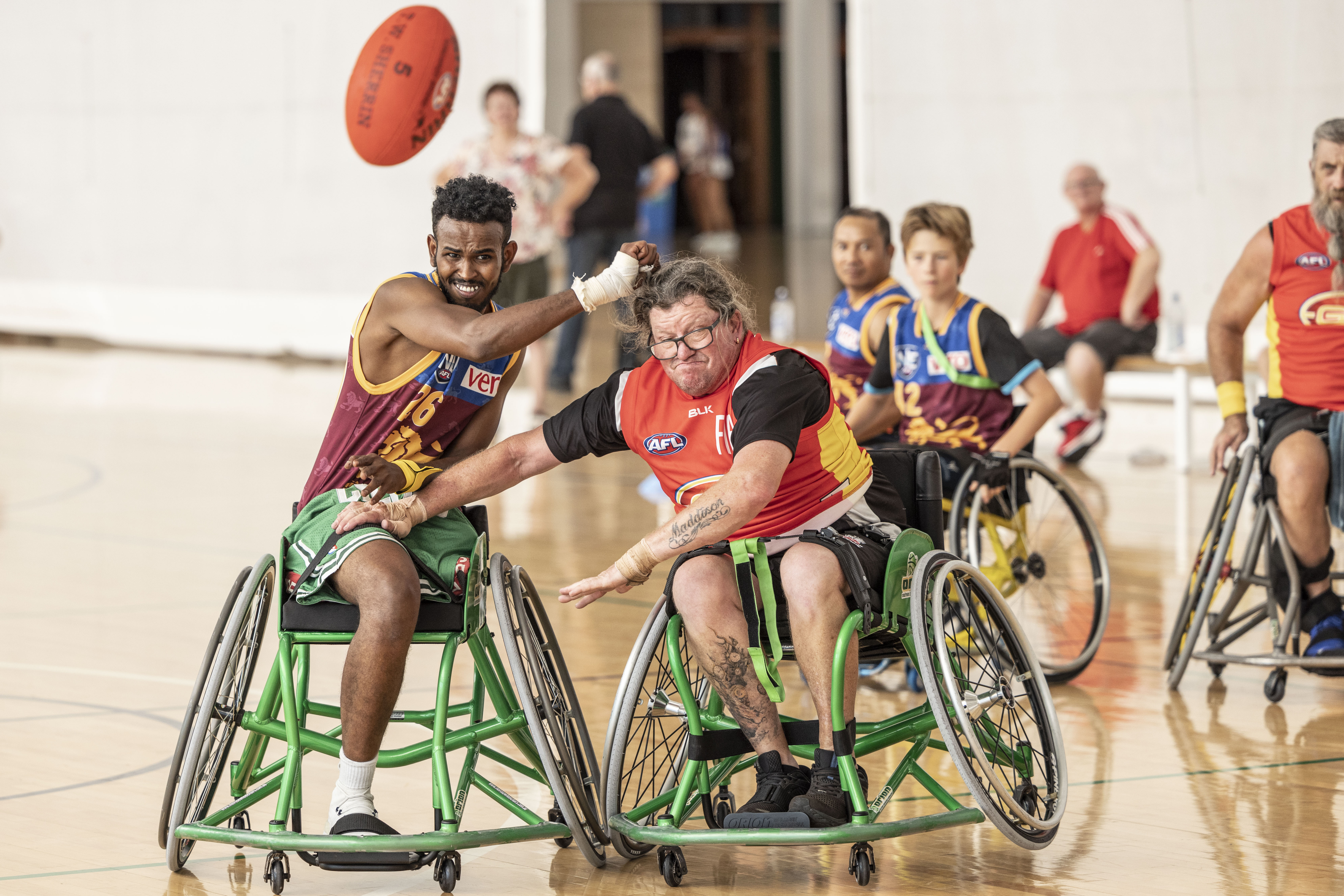 Athletes compete for the ball as they play wheelchair football