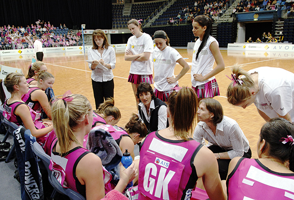 AIS Canberra Darters team sitting on the bench during a Netball match